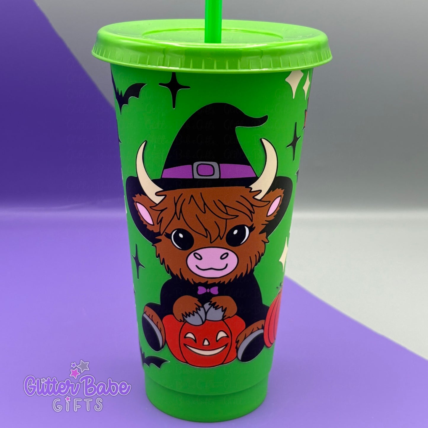 Green Halloween-themed tumbler with a cow wearing a witch hat and sitting with pumpkins.