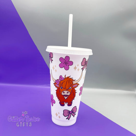 White coloured tumbler with highland cow flowers and bows against a purple and grey background