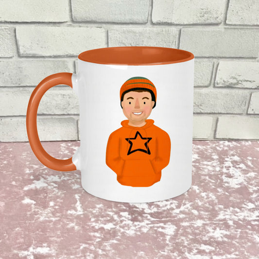 A white and orange ceramic mug with an illustration of a person wearing an orange hoodie with a star on the front.