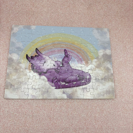 Jigsaw puzzle with a purple dragon and rainbow design on a pink surface