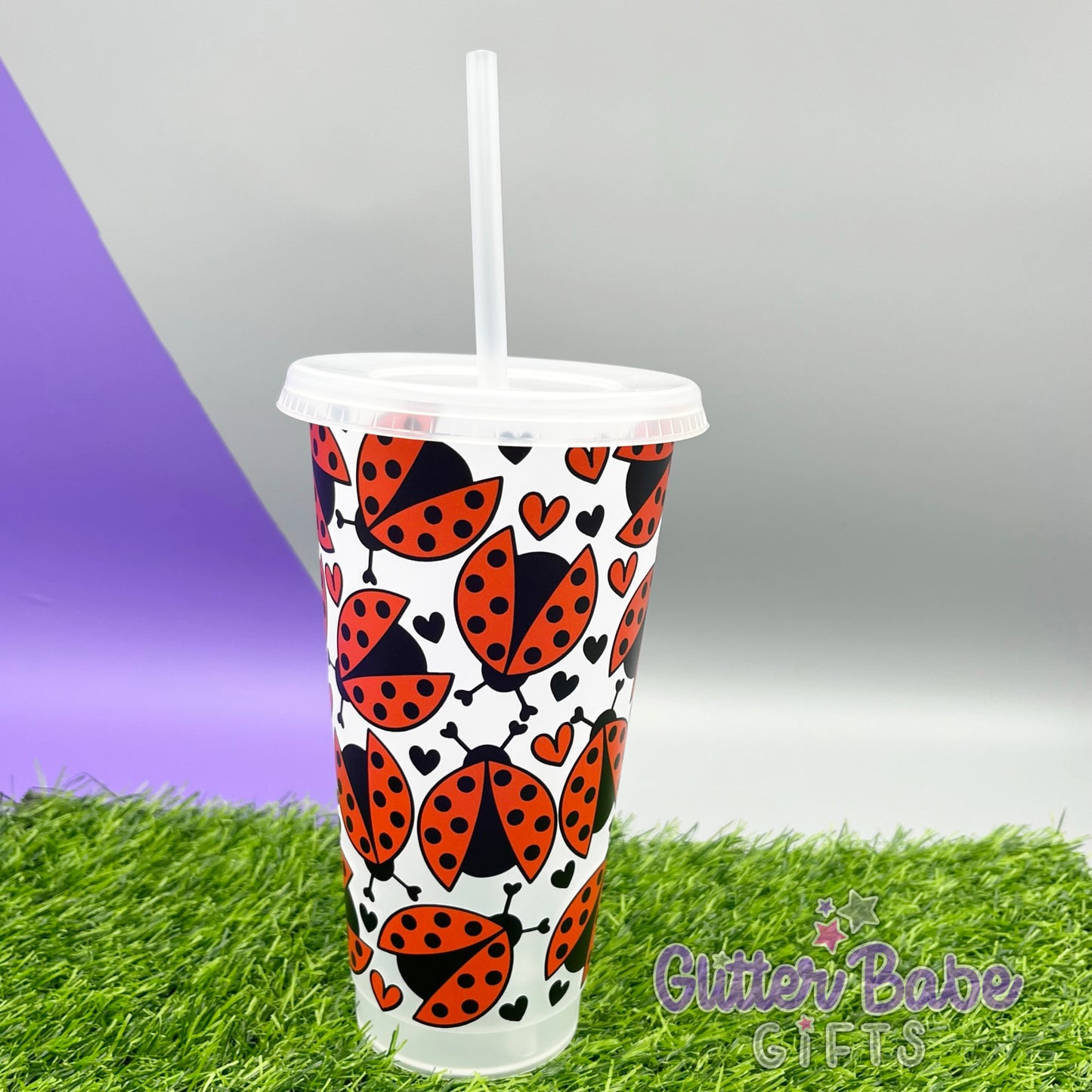 A frosted clear 24oz cold cup with a red and black ladybug design, featuring a straw hole at the top.