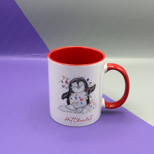 White mug with red interior and handle featuring a penguin design and 'Hot Chocolate' text on a purple and gray background.