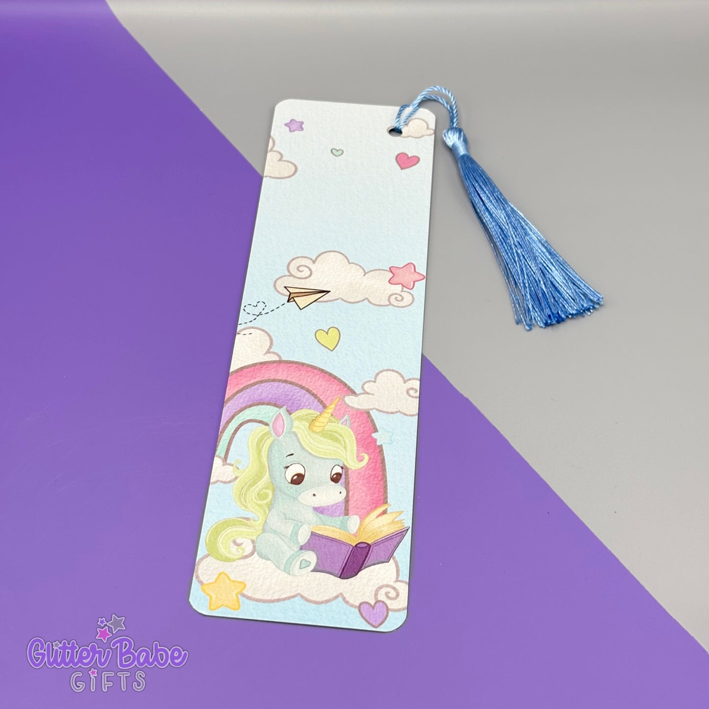 Bookmark with a blue and green unicorn design on a purple and grey background.