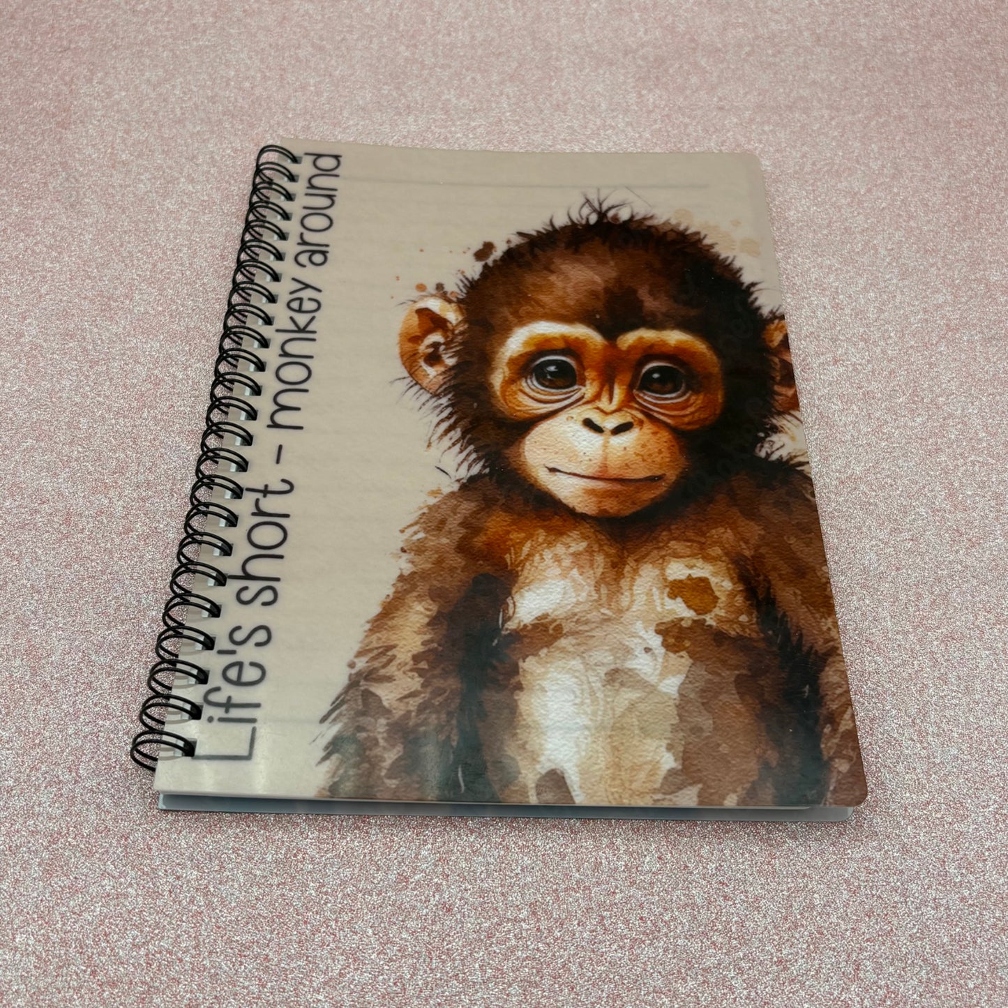 Notebook with a monkey illustration and text on a textured surface
