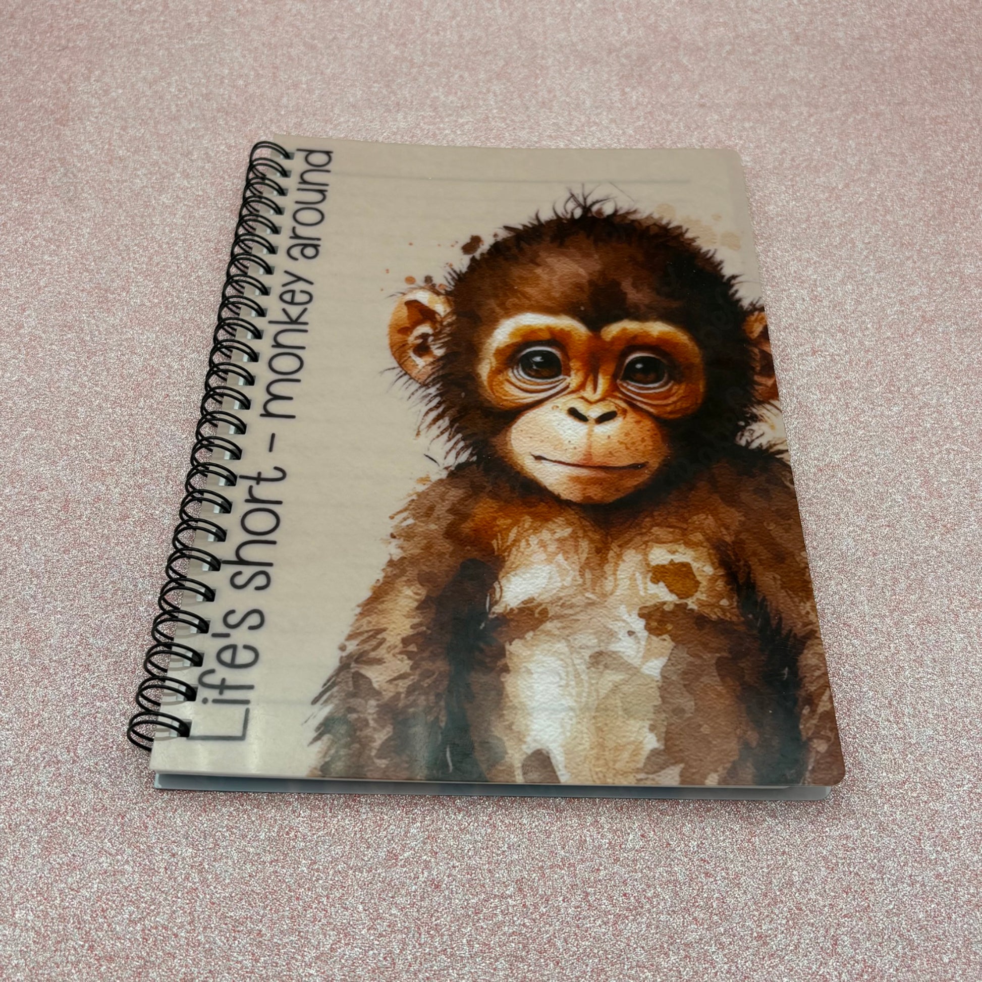 Notebook with a monkey illustration and text on a textured surface