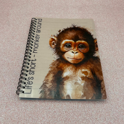 Notebook with a monkey illustration and text on a textured surface
