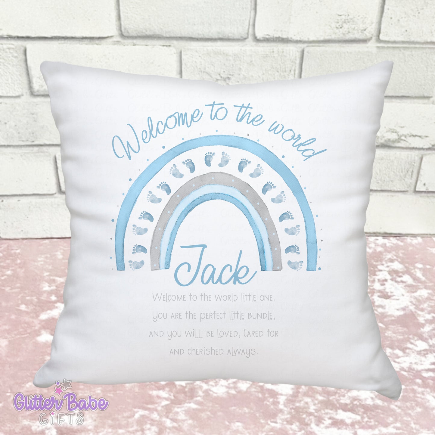 White Cushion with Blue baby feet themed rainbow and writing