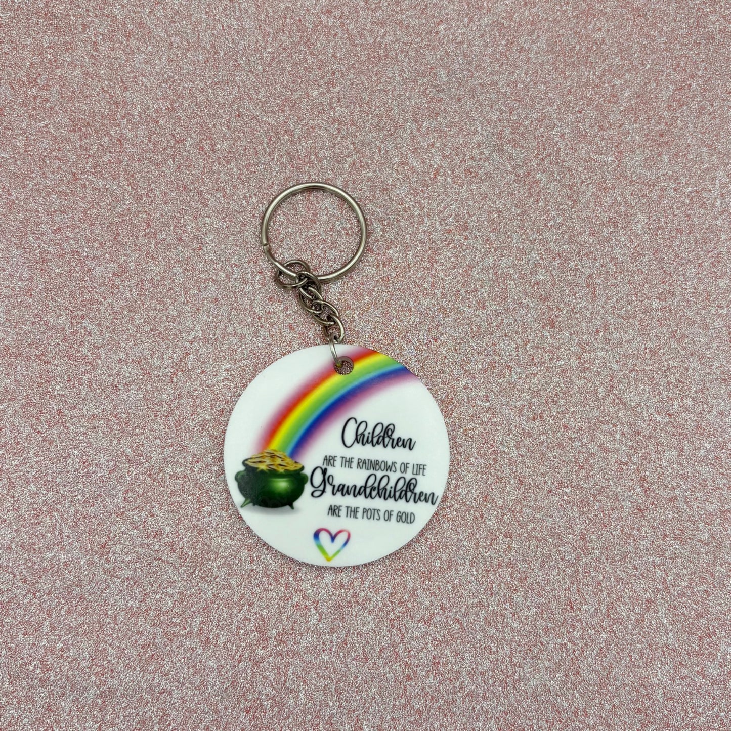 Keychain with rainbow design and text on a textured surface