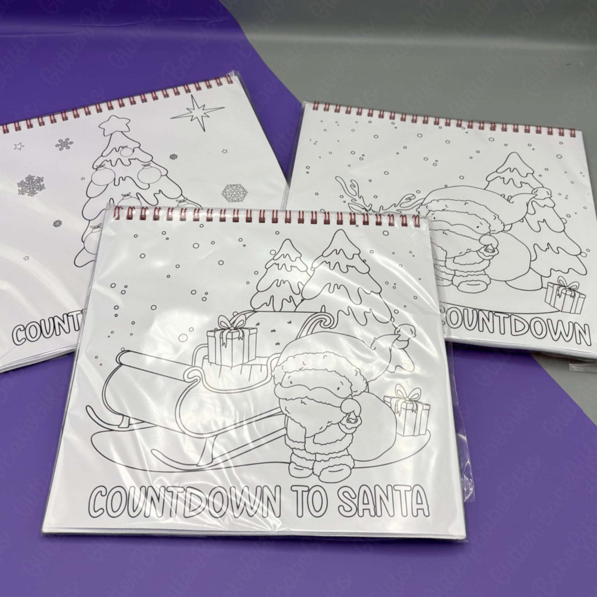 Colouring books with Christmas-themed illustrations on a purple surface