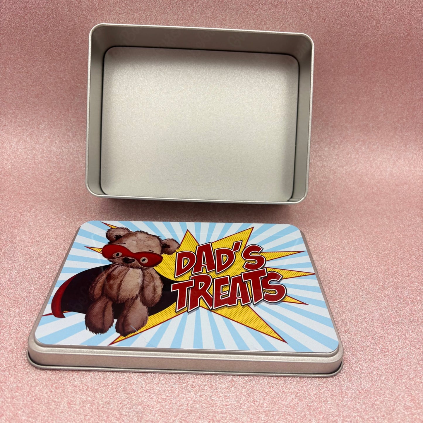 Tin box with a cartoon bear and 'Dad's Treats' text on a pink background