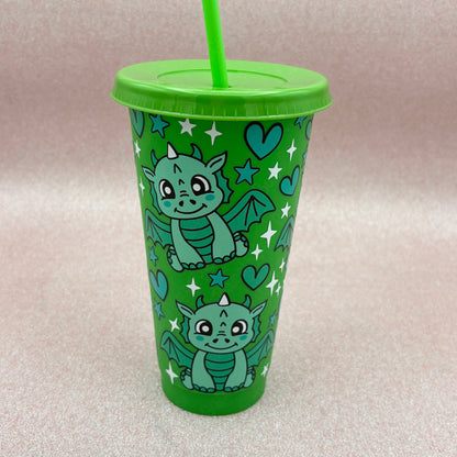 Green tumbler with dragon design on a pale pink background