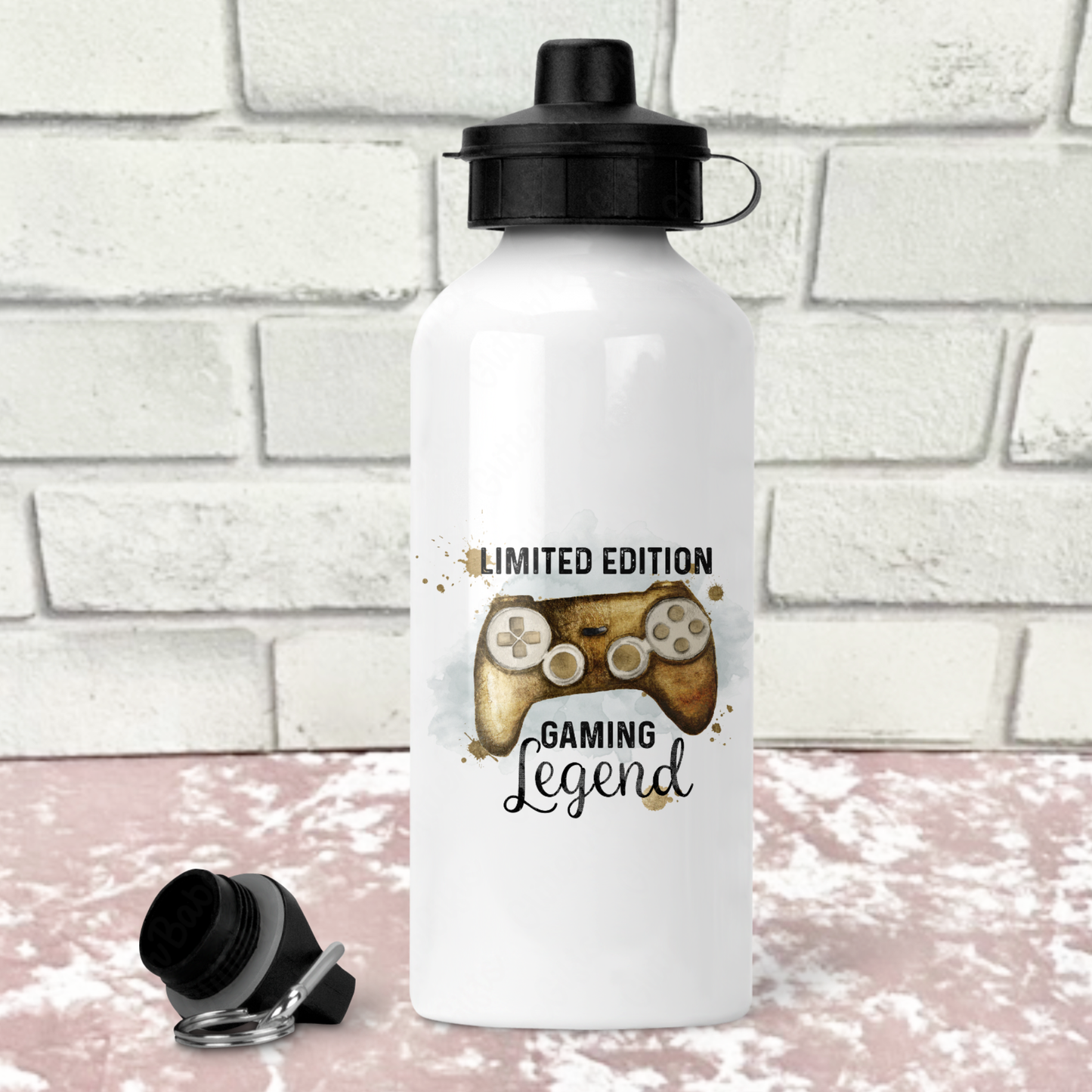 White water bottle with a gold gaming-themed design on a white brick background