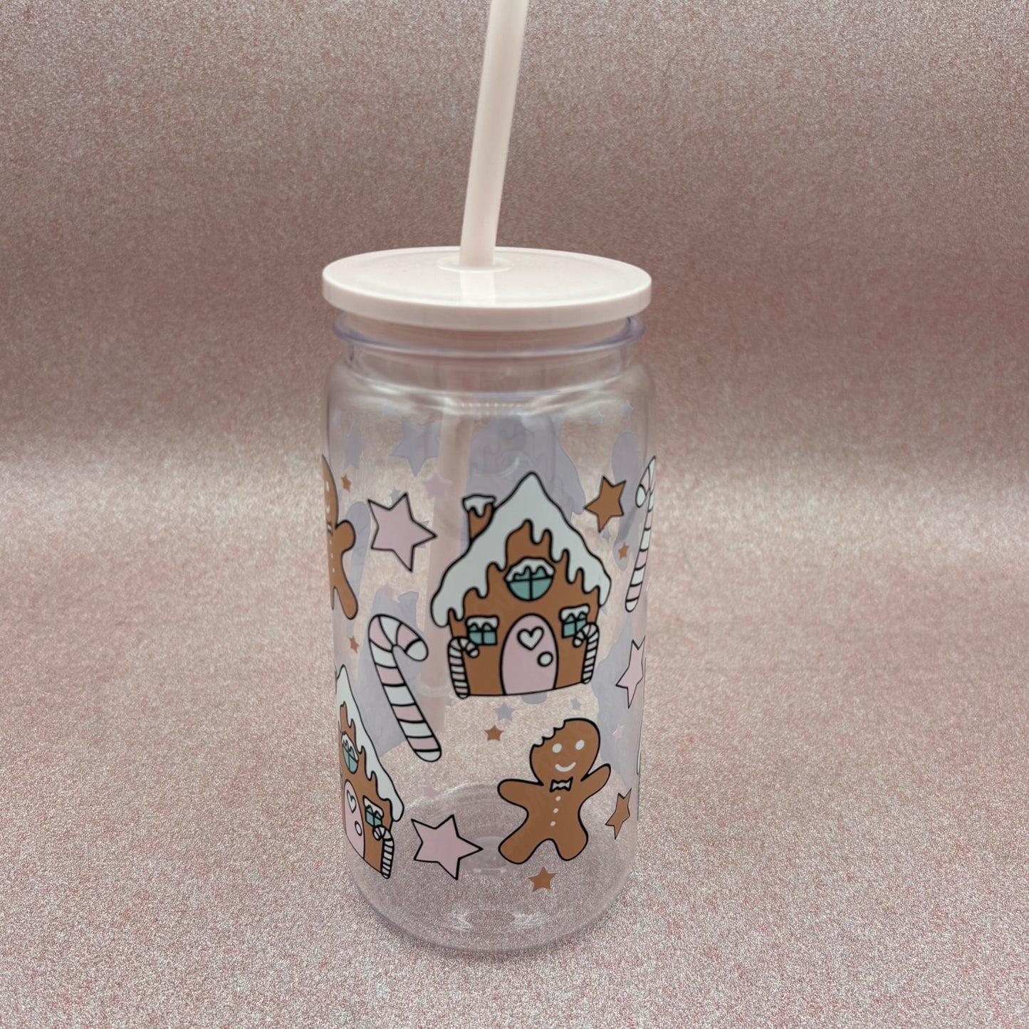 Clear tumbler with gingerbread-themed design on a glittery surface