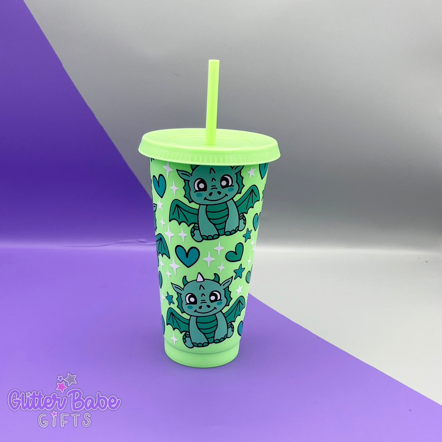 A Bright Green tumbler with two tone green dragon, green hearts and white and green stars design on a purple and grey backdrop