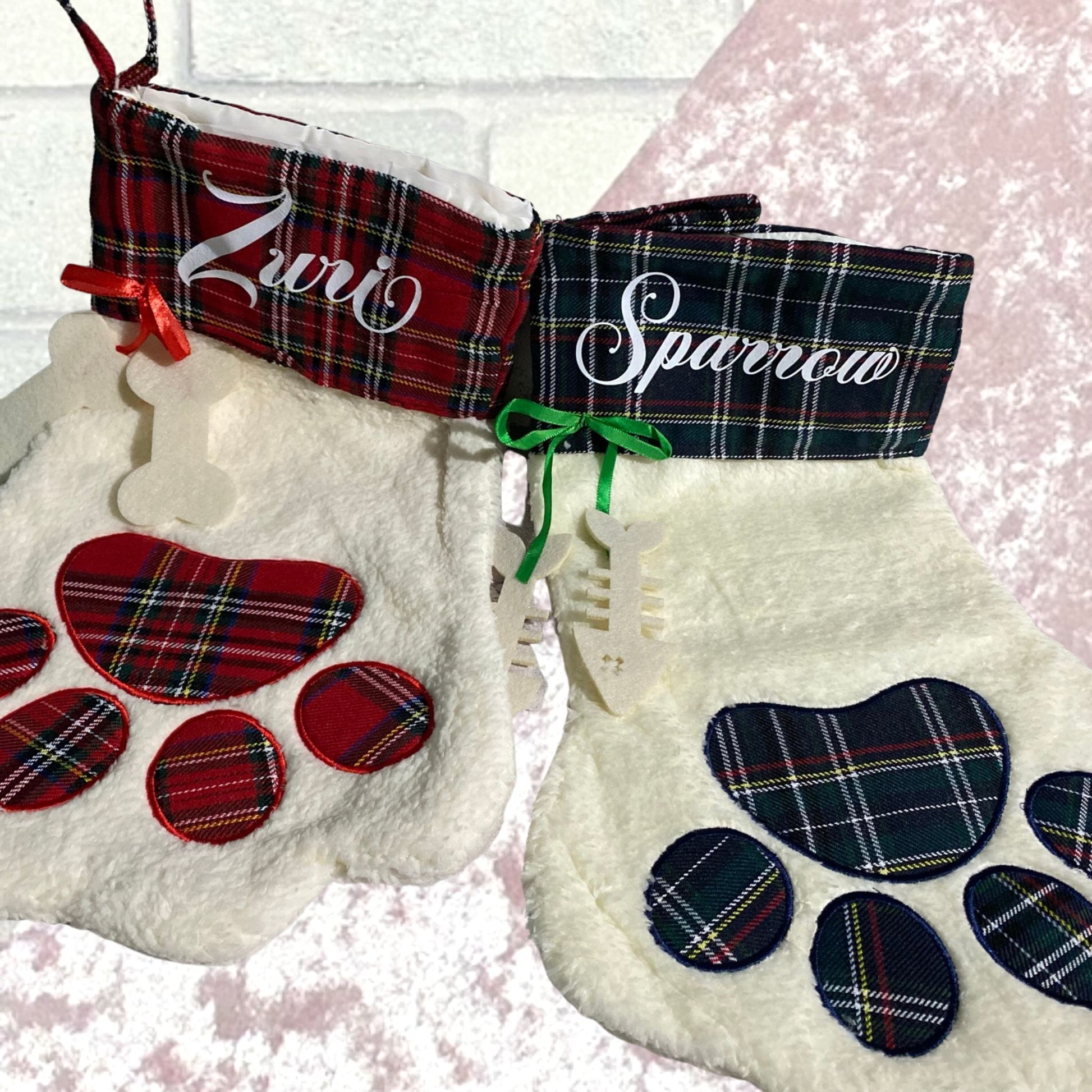 Creamy paw shaped fleece fabric stocking with tartan trim around cuff and tartan paw design. green and red versions red with pet name in white on cuff area