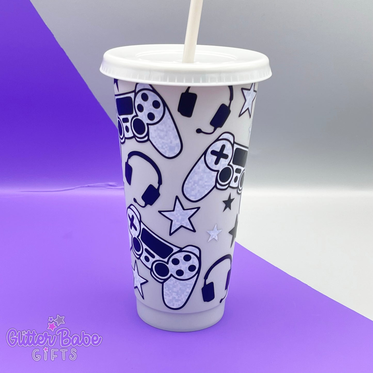 a light grey coloured cold cup with grey and black coloured gaming controller themed pattern against a purple and grey backdrop