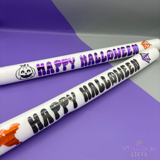 Two 'Happy Halloween' party foam glowsticks on a purple and gray background with Glitter Babe Gifts branding.