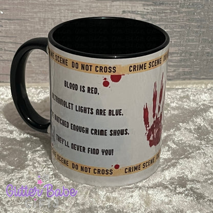 White mug with black inner and handle with writing and image of bloody handprint and crime scene tape