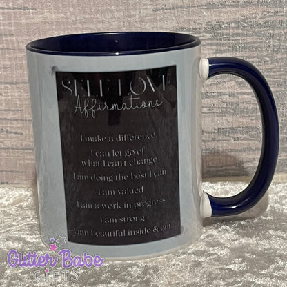 silver and black design with self love affirmations on white mug with dark blue handle and inner