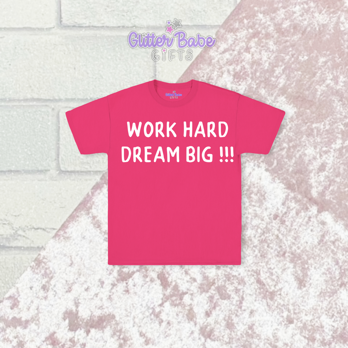 pink t-shirt with white writing on  a pink and brick background 