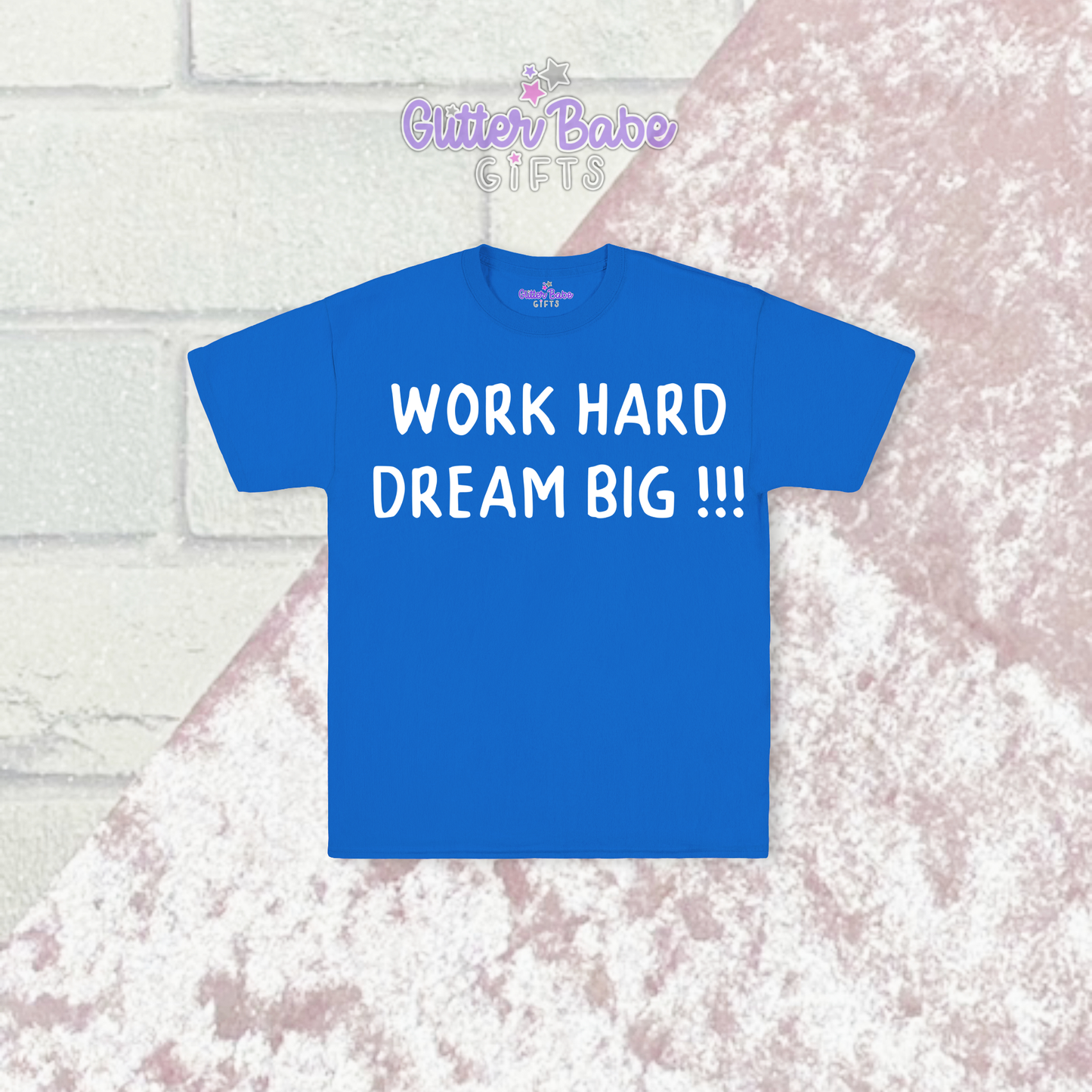 Blue t-shirt with white writing on  a pink and brick background 