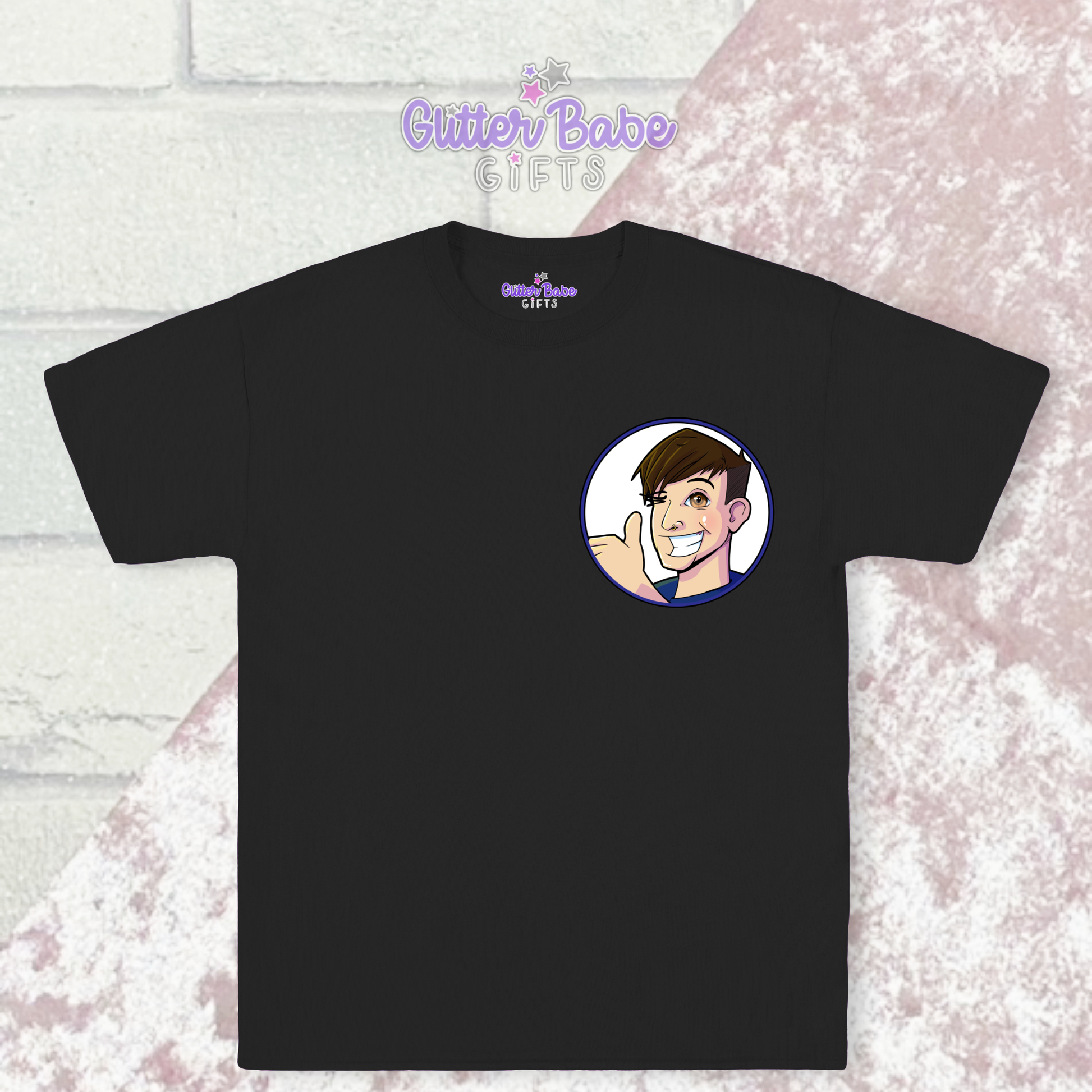 Black t-shirt with cartoon logo on left chest  laying on pink and white background