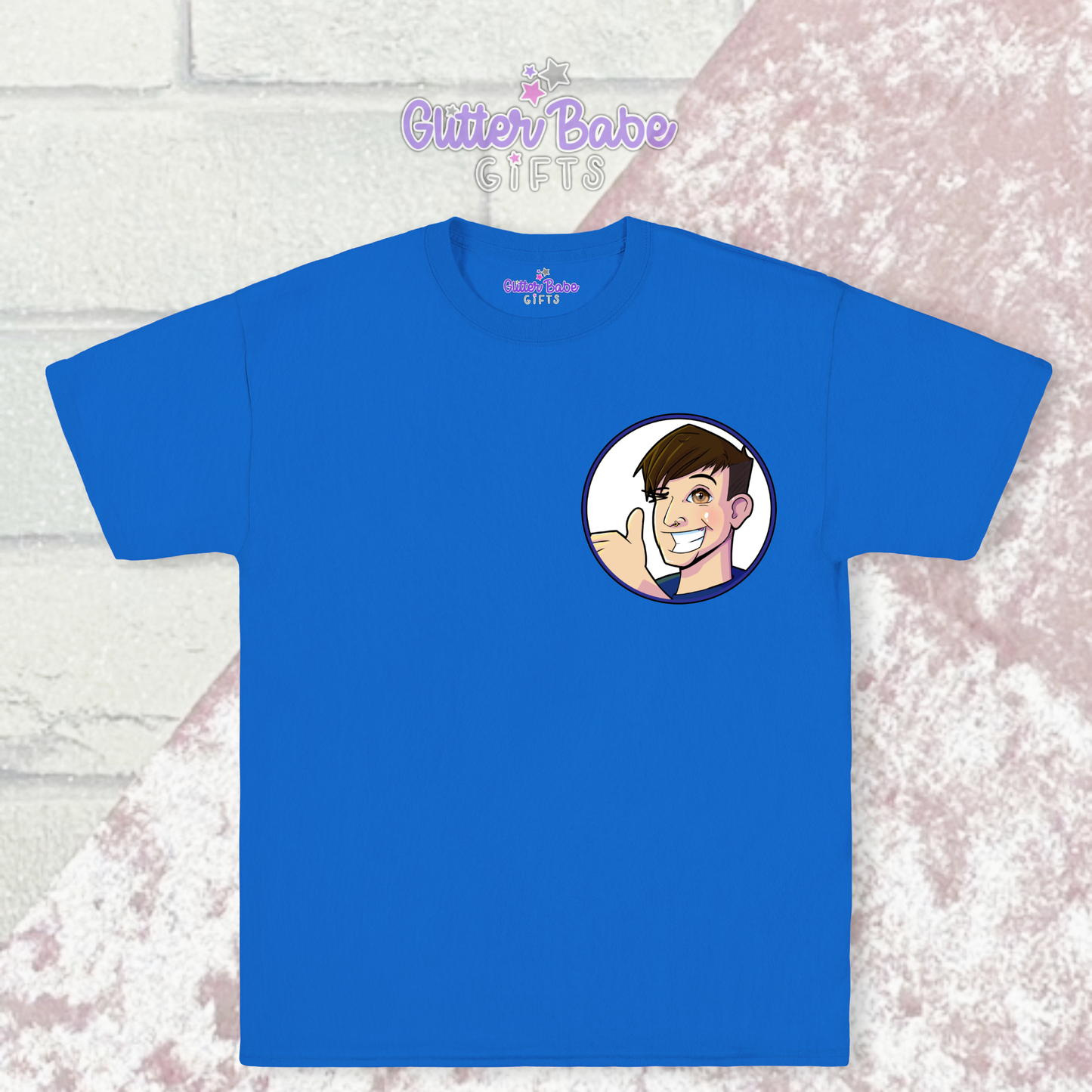 Blue t-shirt with cartoon logo on left chest laying on pink and white background