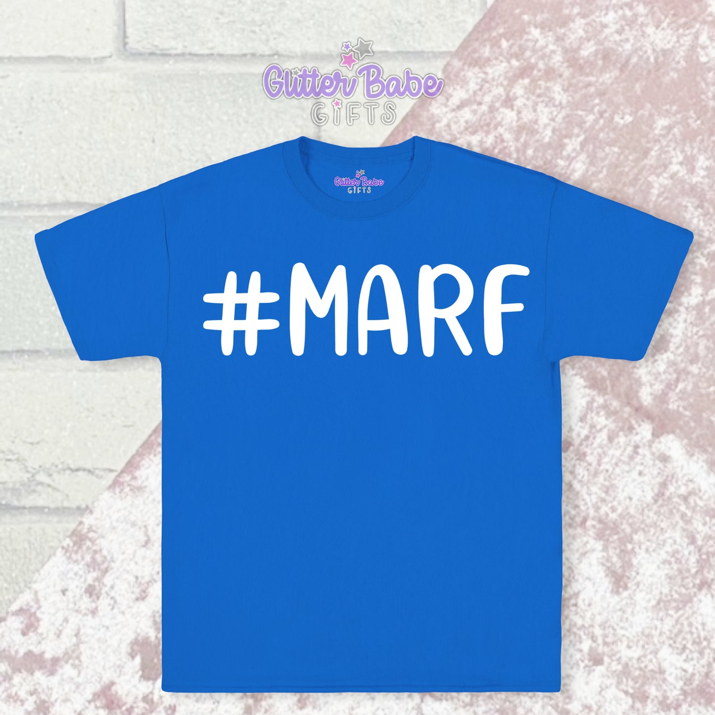 Blue T-shirt with white writing saying #marf little a big f with a pale pink and white backdrop