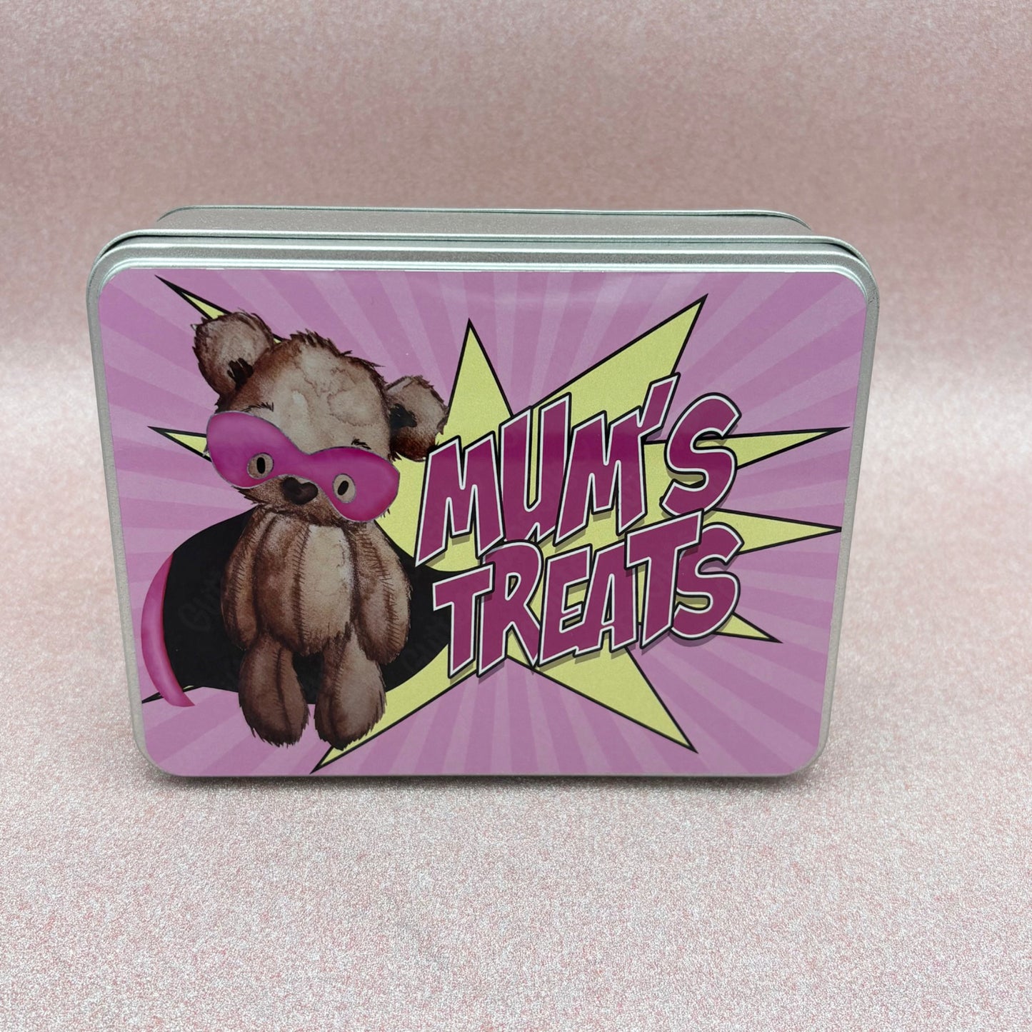 Tin box with a teddy bear illustration and 'Mum's Treats' text on a pink background