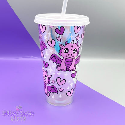 A opal coloured tumbler with two tone pink dragon, pink hearts and white and pink stars design on a purple and grey backdrop