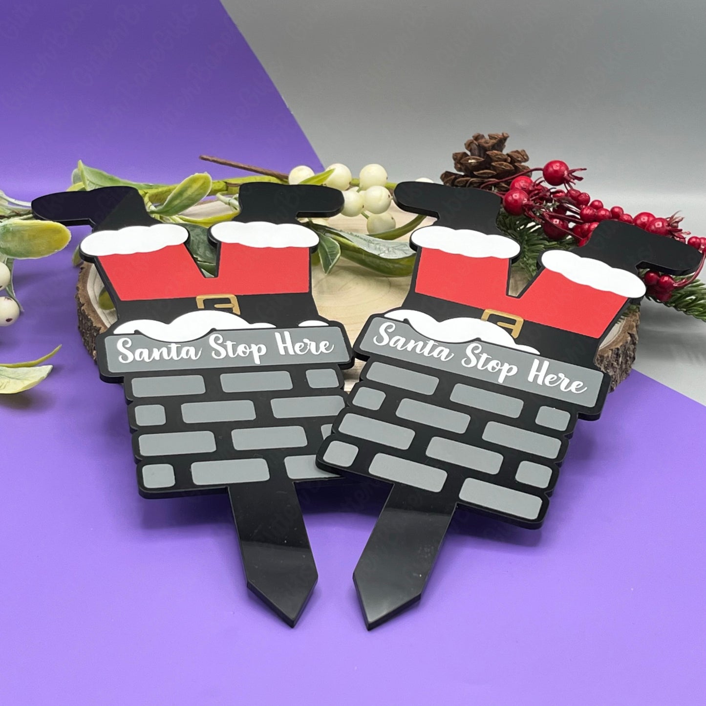 Two decorative signs shaped like a brick wall with Santa hats and 'Santa Stop Here' text, on a purple background.