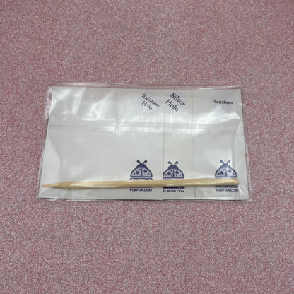 Back View of Packaged scratch art showing the wooden stylus and variations of scratch panels  on a textured pink background