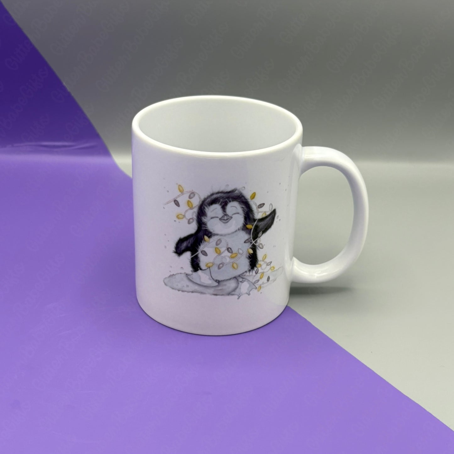 White mug with a penguin design on a two-tone purple and gray background