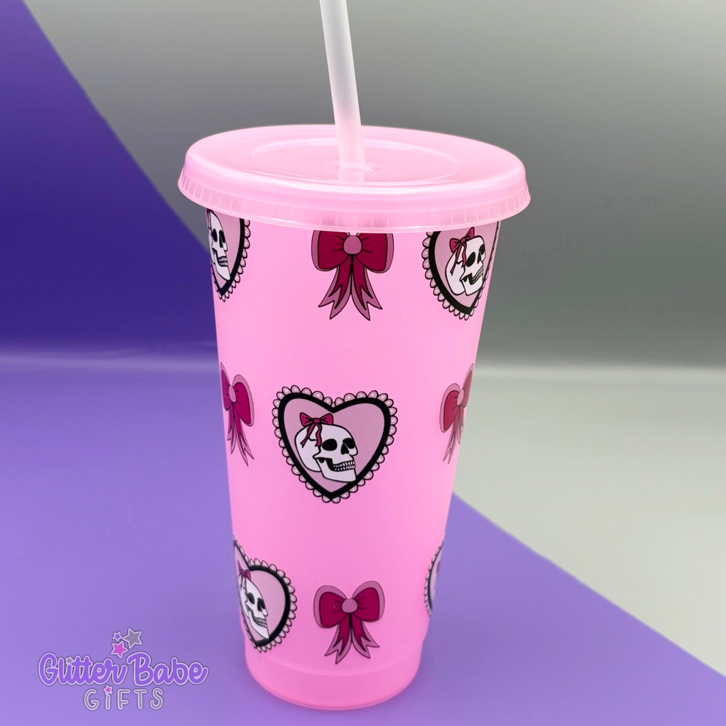 Pink glow in dark tumbler with skull and bow design on a gradient background
