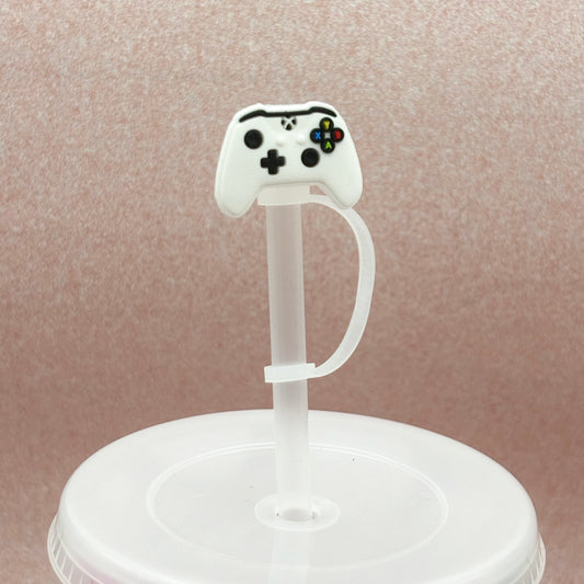 White gaming controller shaped straw topper displayed on a clear straw against a pale pink background