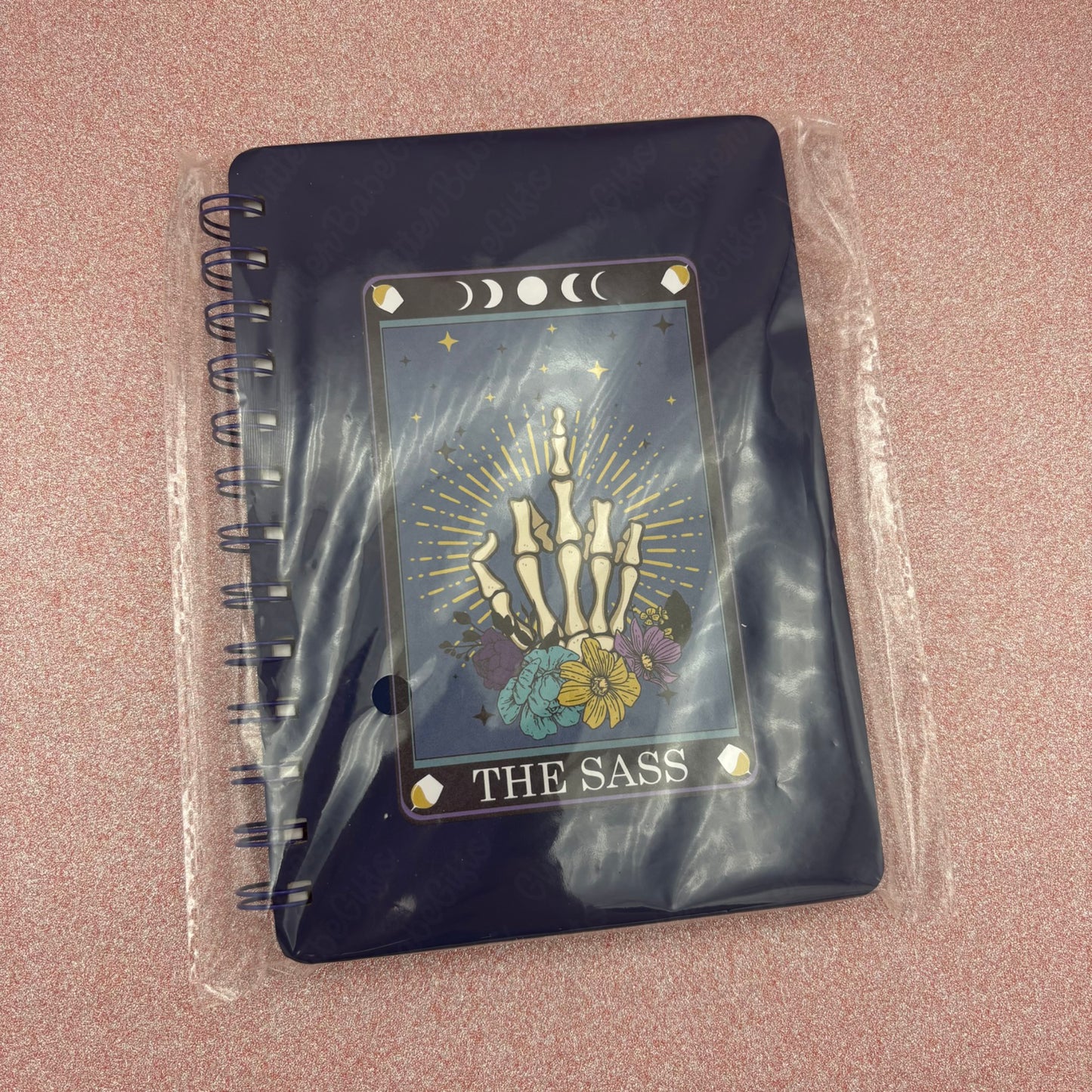 Dark Blue  notebook with 'The Sass' design on a pink surface