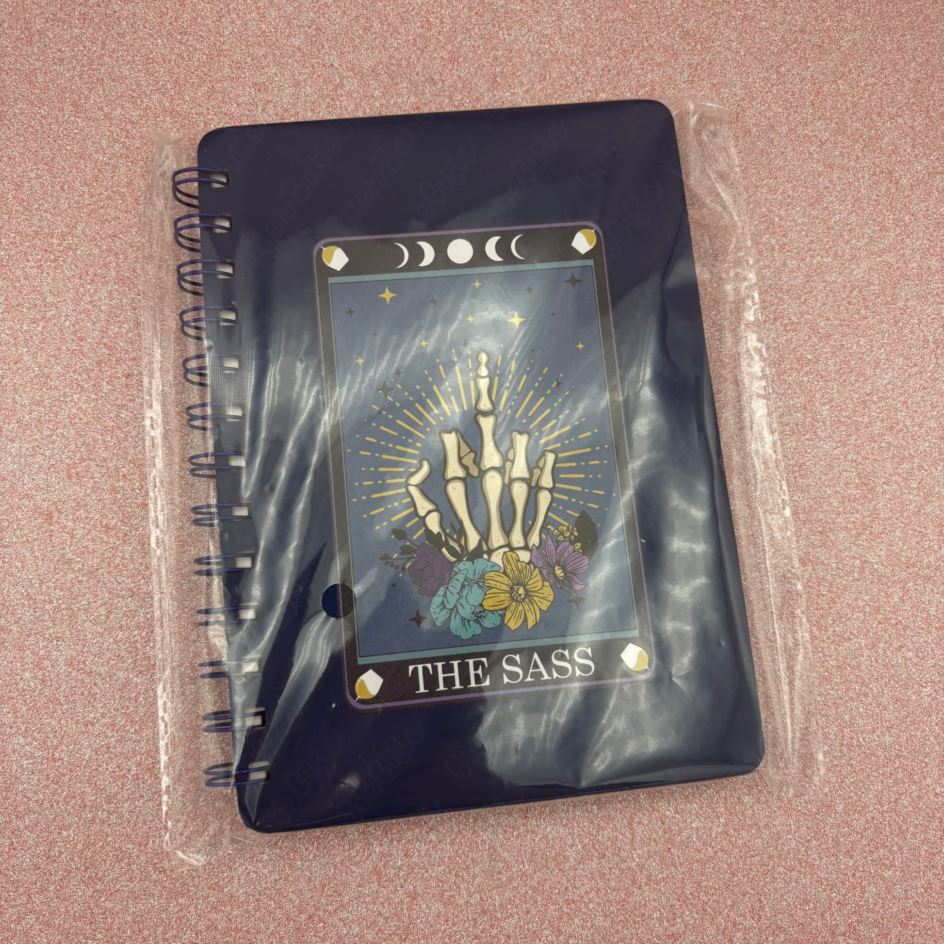 Dark Blue  notebook with 'The Sass' design on a pink surface