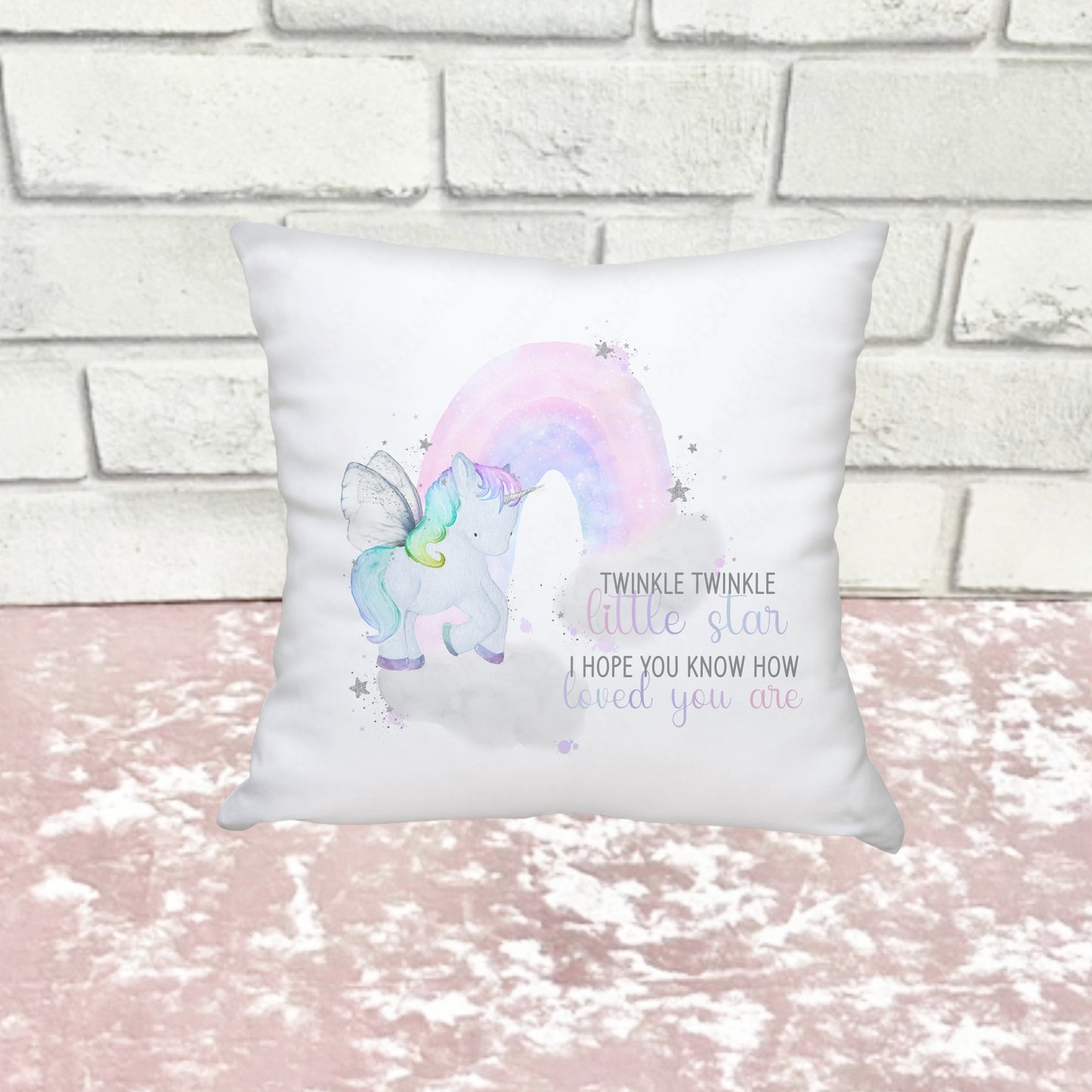 A unicorn design on a white cushion against a white and pink background