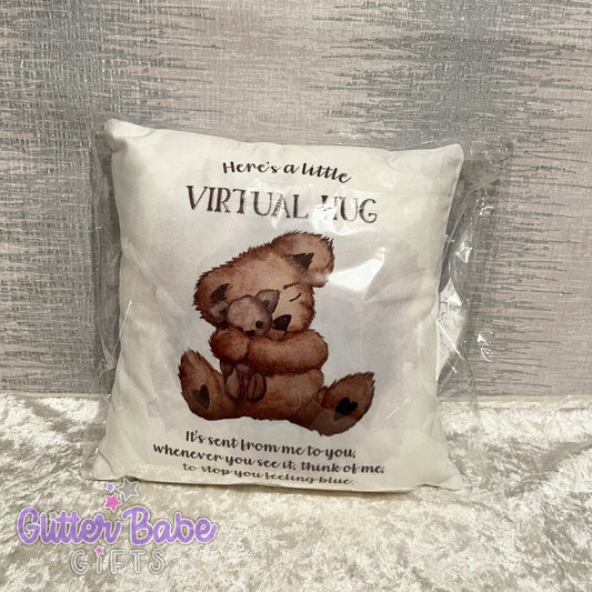A packaged mini cushion with a bear design and the text 'HERE'S A LITTLE VIRTUAL HUG' on it.