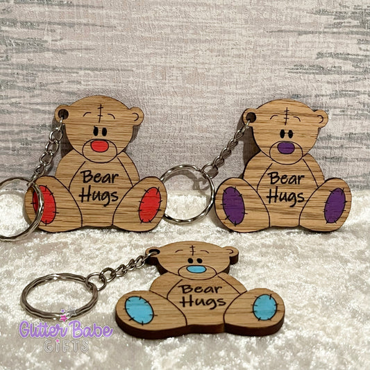 a trio of wooden bear shaped keychains with coloured noses and paws