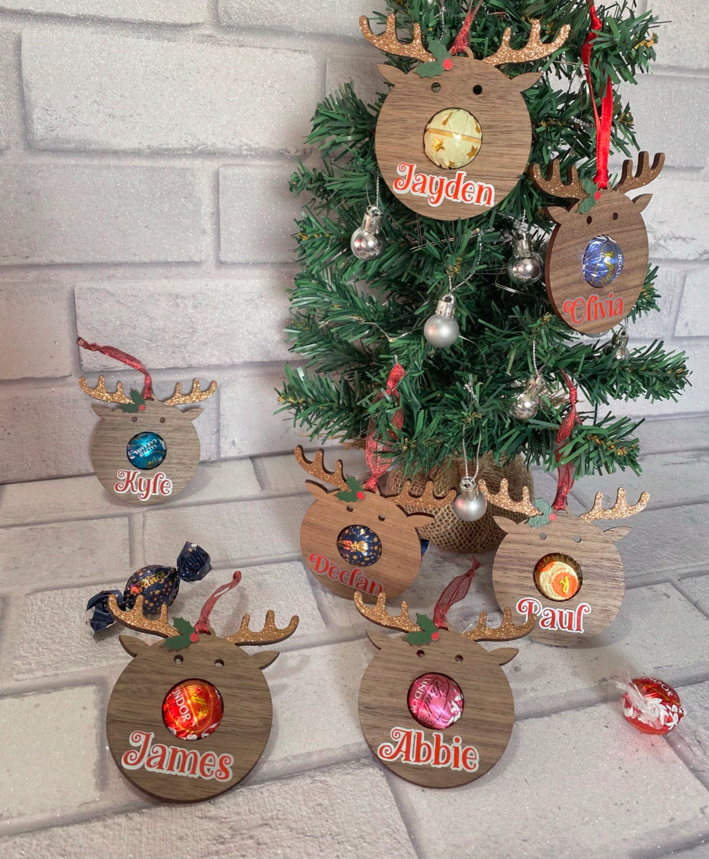 A display of reindeer head shaped flat wooden baubles containing various sweets