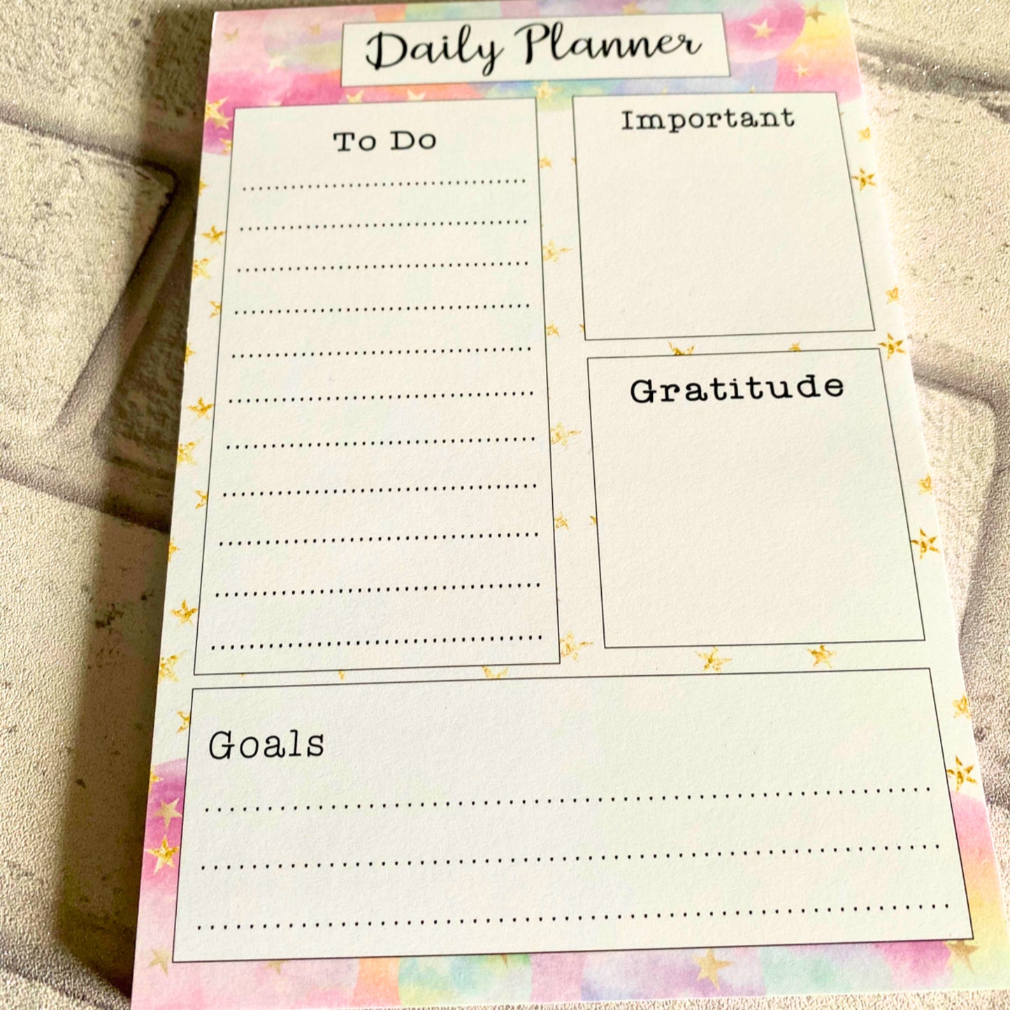 Daily planner with colourful cloud effect and gold stars with section boxes for To do list , Important , Gratitude and Goals