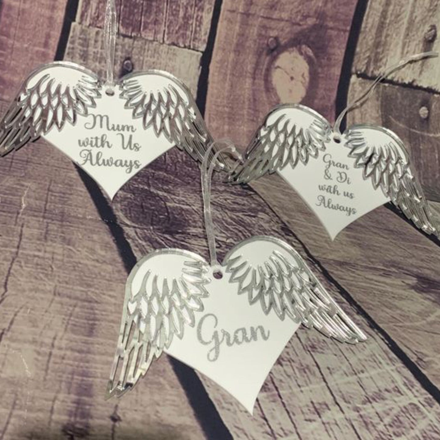 Three white hanging heart on white ribbon with mirrored silver wing details and writing in a matching silver